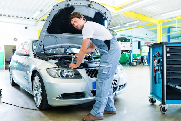 Auto mechanic working in car service workshop