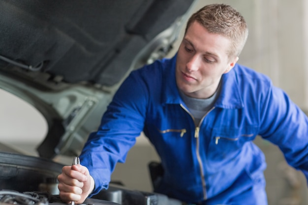 Auto mechanic working on car