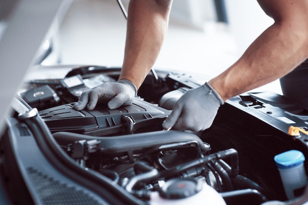 Foto meccanico che lavora in garage. servizio di riparazione