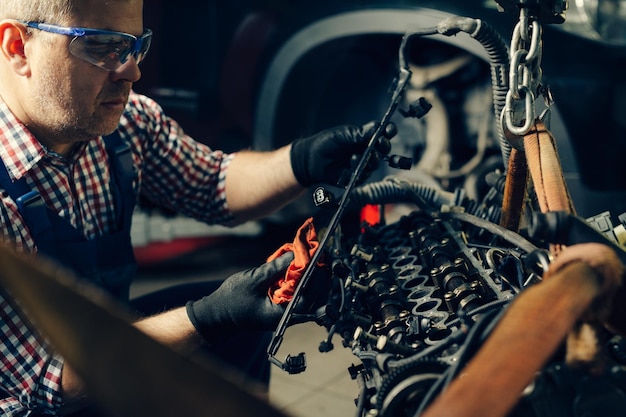 Foto meccanico che lavora in garage servizio di riparazione