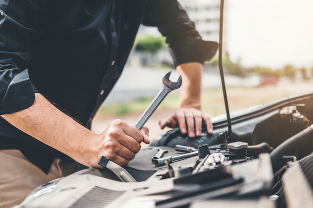 写真 ガレージで働く自動車整備士技術者自動車修理で働く自動車整備士の手