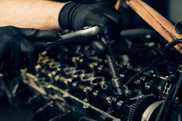 Auto mechanic working and repair on car engine in mechanics garage