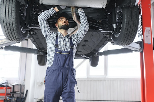 Auto mechanic working underneath a lifted car