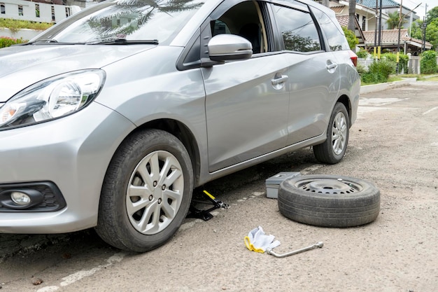 Auto met krik en moersleutel voor het vervangen van banden