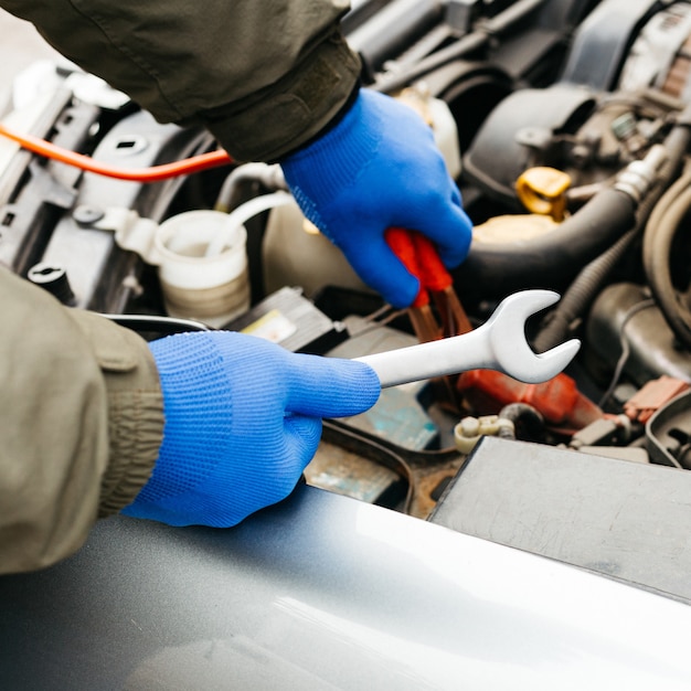 Auto monteur ingenieur met behulp van een moersleutel tijdens de vaststelling van een auto