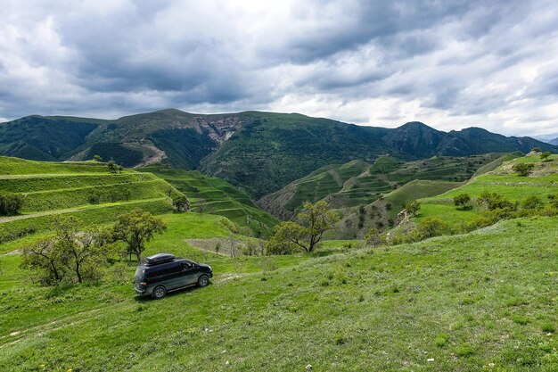 Auto op de achtergrond uitzicht op de bergen van Dagestan nabij het dorp Gamsutl Rusland juni 2021