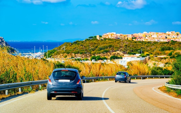 Auto op de weg in Porto Rotondo in de buurt van Porto Cervo in Costa Smeralda op het eiland Sardinië in de zomer van Italië. Vervoer rijden op de snelweg van Europa. Uitzicht op snelweg. provincie Olbia. Gemengde media.