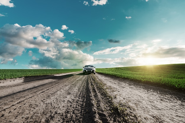 Auto op een onverharde weg en een veld met groen gras