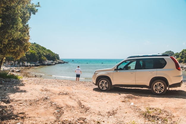 Auto reizen concept man op zomer strand kijken naar zee