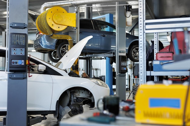 Auto-reparatiewerkplaats Auto's met open motorkap geparkeerd in de garage voor reparatie- en onderhoudsdiensten
