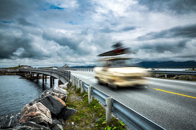 Auto rijdt op de snelweg. Caravan auto in bewegingsonscherpte. Noorwegen. Atlantic Ocean Road of de Atlantic Road (Atlanterhavsveien) is bekroond met de titel "Noorse constructie van de eeuw".