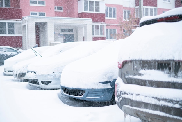 Auto's bedekt onder sneeuw tijdens de winter, stormachtig weer buiten