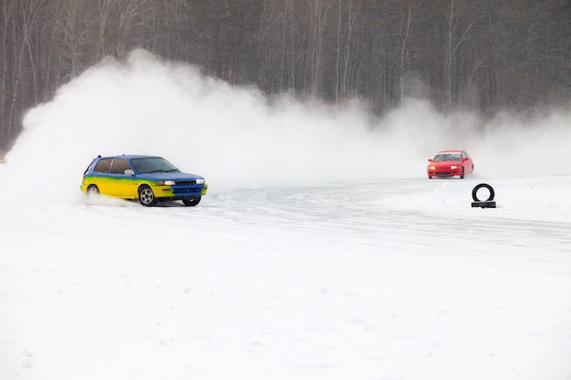 Foto auto's die op ijs rijden en veel ijsspatten maken tijdens sneeuwval