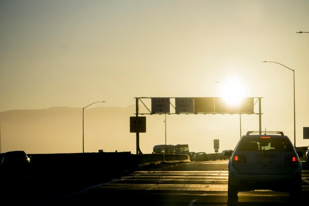 Auto's op de weg tegen de hemel tijdens de zonsondergang