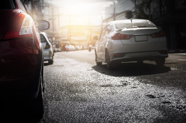 Auto's op natte weg na harde regen vallen met avondlicht in de stad, selectieve focus. Regenseizoen, transportachtergrond.