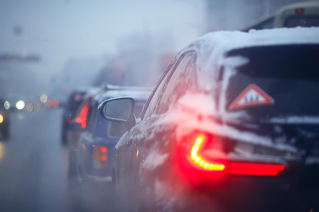 auto's op winterweg verkeersopstopping stad / winterweer op de stadssnelweg, het uitzicht vanuit de auto in de mist en sneeuwweg