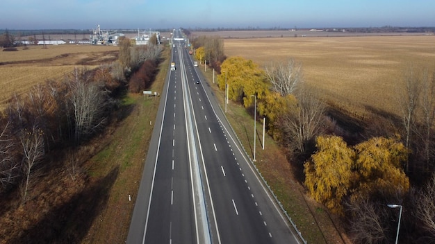 Auto's rijden langs de snelweg op een autoweg op een zonnige herfstdag met witte markeringen tussen ag