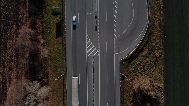 Auto's rijden langs de snelweg op een zonnige autoweg in de herfst met witte markeringen tussen agricultu