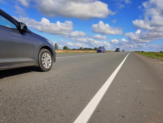 Foto auto's rijden langs de weg op een zonnige zomerdag