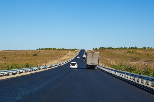 Auto's rijden op een nieuwe asfaltweg zonder markeringen