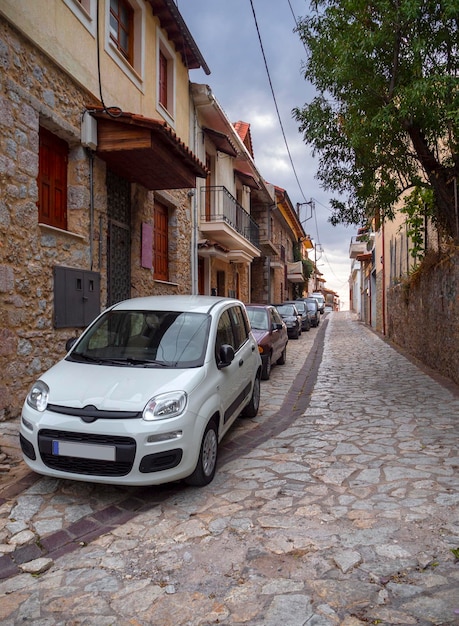 Auto's staan geparkeerd in een smal straatje van het vakantieoord Arachova op de berg Parnassus in Griekenland