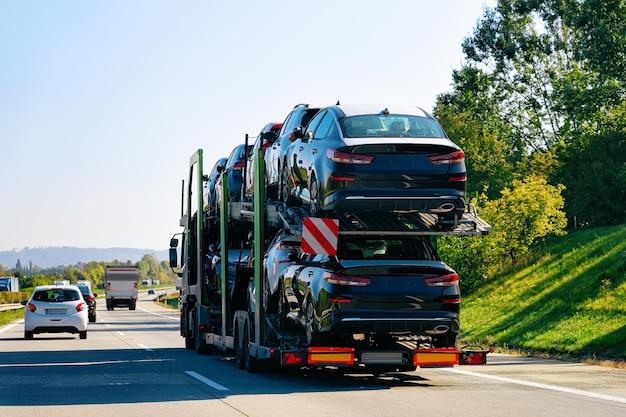 Auto's vervoerder vrachtwagen op de asfaltweg, Polen. Vrachtwagentransporter