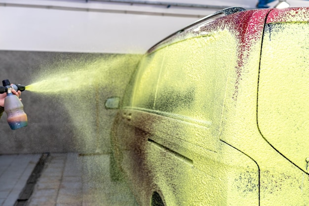 Auto's wassen met groen actief schuim in de garage