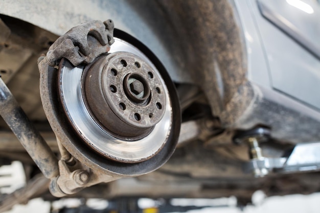 Photo auto service and maintenance concept - car brake disc at repair station