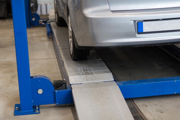 Photo auto service and maintenance concept - car on lift at repair station