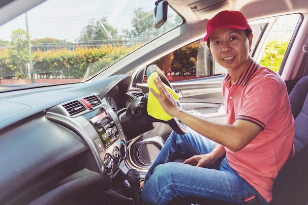 Auto service staff cleaning car with microfiber cloth