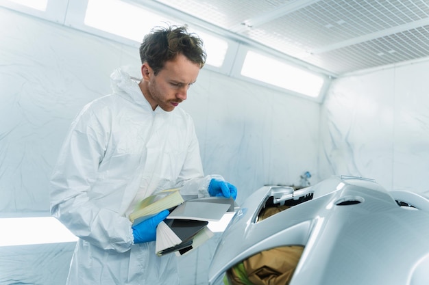 Auto service worker in vehicle painting booth