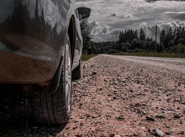 Auto staat op een stoffige landweg, wiel close-up