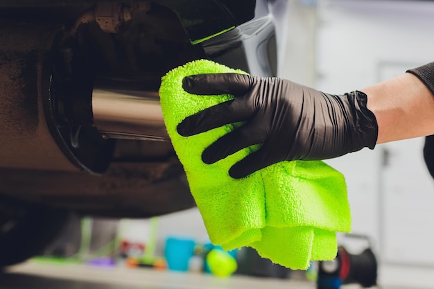 Auto-uitlaatpijp met zeep Car wash achtergrond close-up van een groene doek