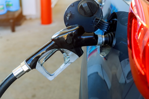 Auto vullen met benzine bij een benzinestation, benzinestationpomp.