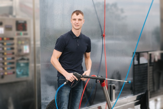 Auto wassen. Auto reinigen met hogedrukwas voor glans. Man zijn auto buiten wassen.