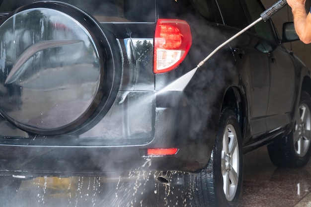 Auto wassen. Auto schoonmaken met water onder hoge druk en schuim