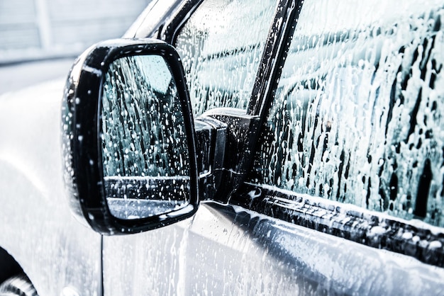 Auto wassen met zeep. Sluit omhoog schoon autoconcept bij autowasserette.