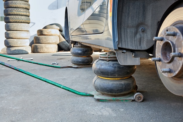 Auto zonder wielen opgetild met krikken tijdens wielvervanging