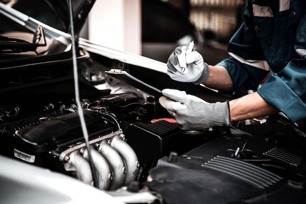 Auto zorg onderhoud en service Closeup hand technicus automonteur inspectie lijst controleren na reparatie wissel onderdeel auto motor probleem en auto verzekering service