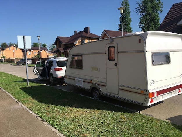 Foto autoaanhanger op de weg met een auto, vertrek vanuit huis.