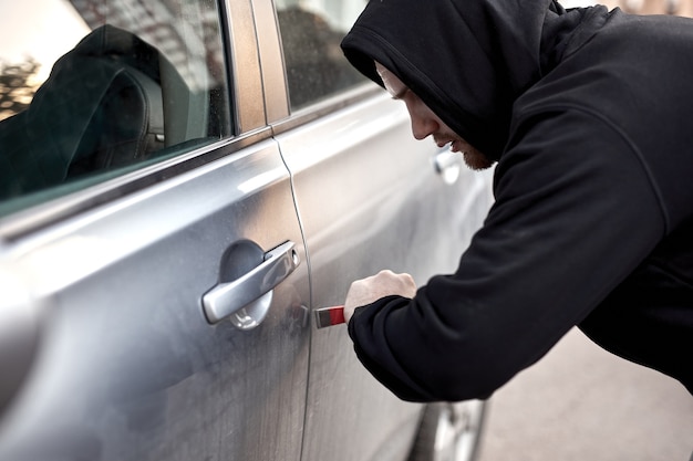 Autodief steelt auto brekende deur criminele baan inbreker Kapt autodief in zwarte kleding