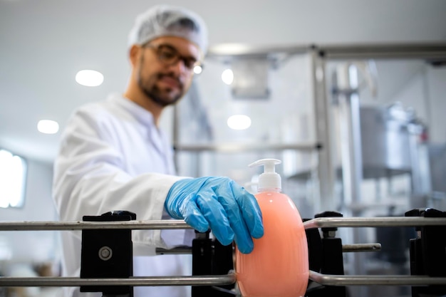 Photo automated industrial production line of liquid soap in chemical factory