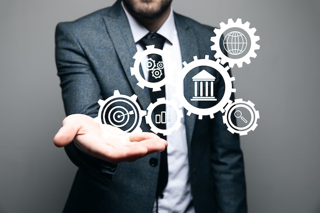 Automatic business management. icons in gears. businessman holds in hand