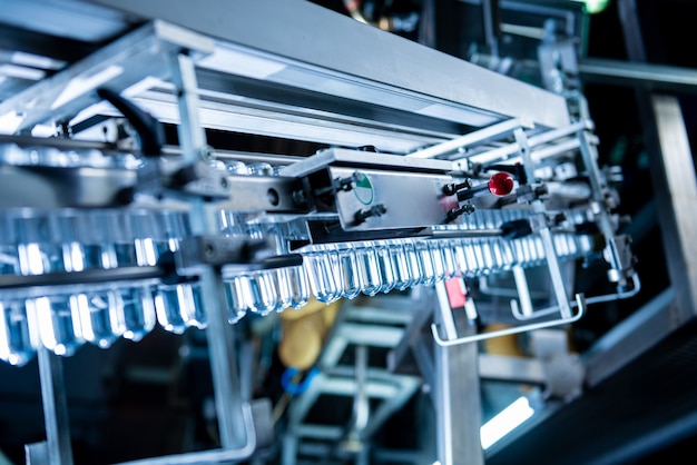 Photo automatic filling machine pours water into plastic pet bottles at modern beverage plant