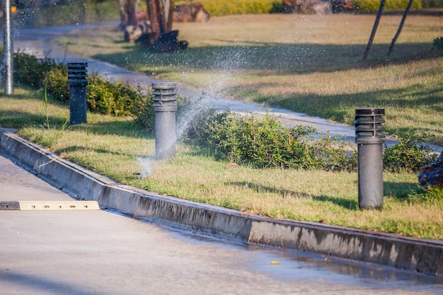 庭の緑の草の上に水をまく自動芝生スプリンクラー