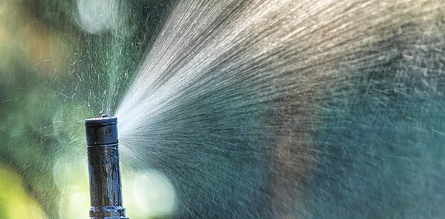 Automatic sprinkler system watering the lawn close up