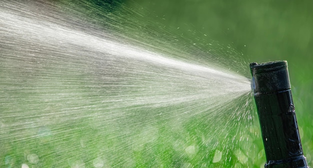 Automatic sprinkler system watering the lawn close up