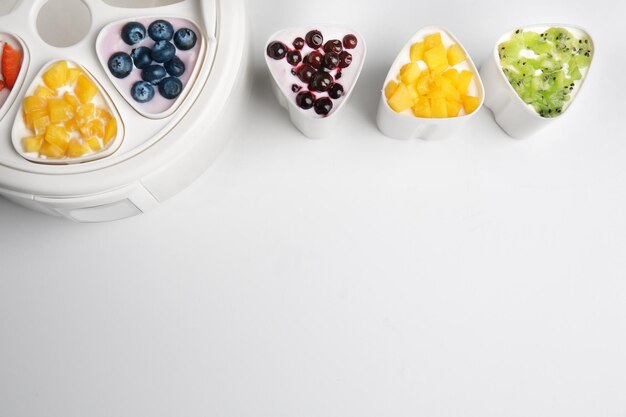 Photo automatic yogurt maker with fruits on white background