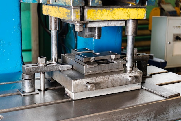 Automation hydraulic press stamping machine production line\
industrial metalworking machines closeup of a hydraulic press in an\
industrial workshop at a factory