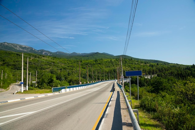 ヨーロッパの山の川を通るアスファルト道路のある自動車橋。高品質の写真